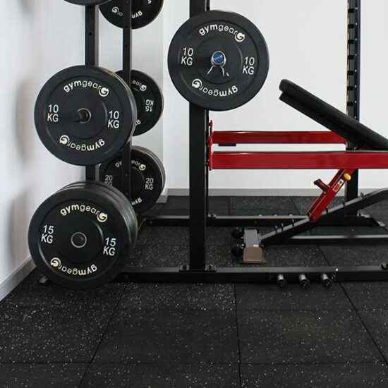 Black bumper plates in the gym and loaded on a machine