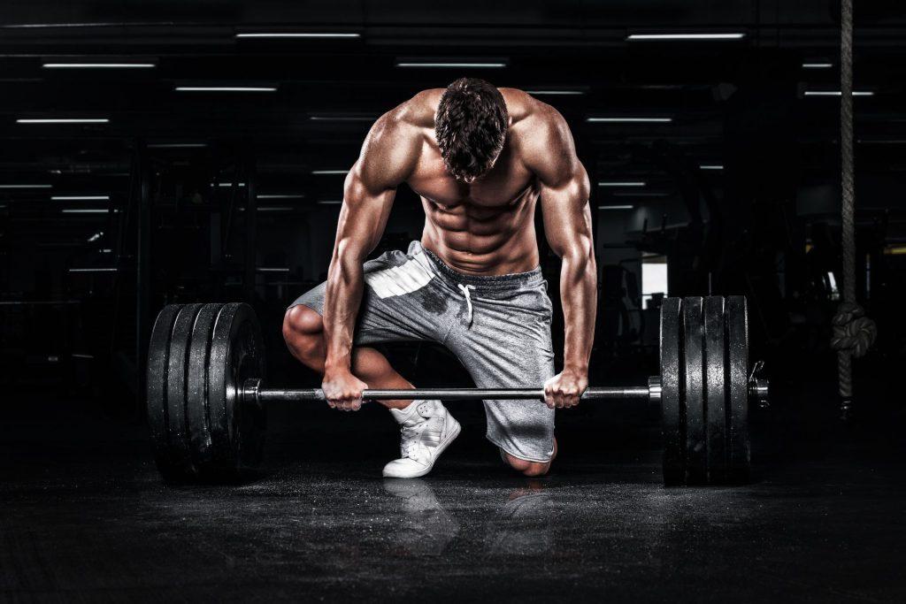 Weight Lifter looking defeated at a barbell weight set