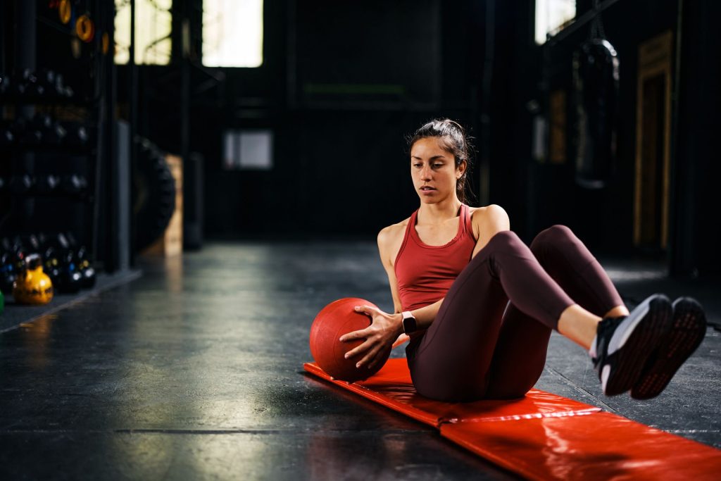 Woman training in a gym using a medicine ball