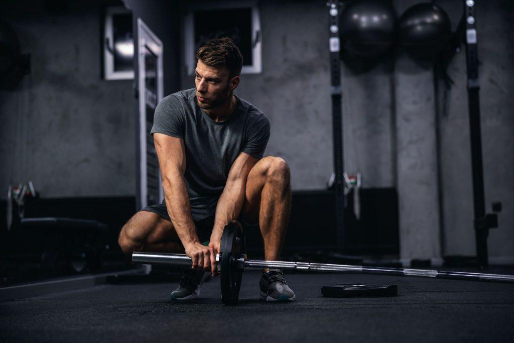 Personal Trainer adjusting weight on a barbell weight set